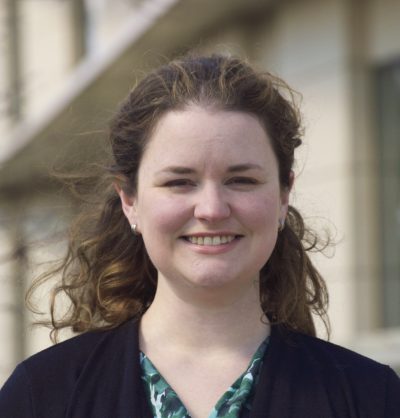 A woman smiling while looking directly into the camera.